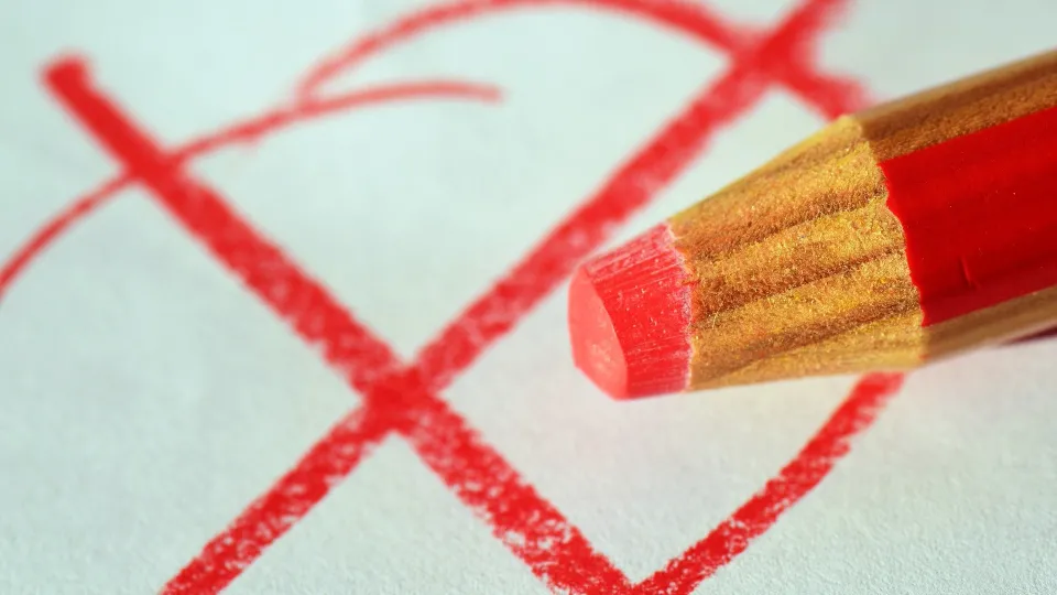 Stimmungsbild zum Beitrag: Es wird ein roter Stift mit einem roten Kreuz auf einem Blatt Papier abgebildet.